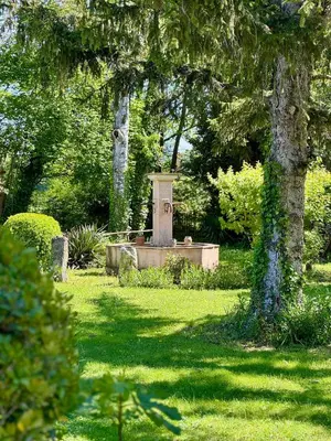 a statue in a park with trees and grass at Les Oliviers- Bed and Breakfast in Velleron