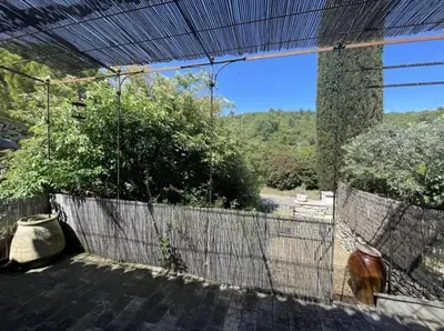a patio with a fence and a view of a yard at Le cabanon in Saint-Martin-de-Castillon