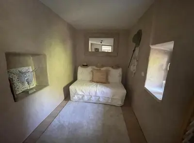 a small room with a bed and a mirror at Le cabanon in Saint-Martin-de-Castillon