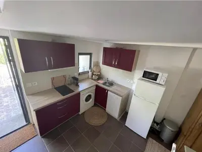 a small kitchen with a refrigerator and a microwave at Le cabanon in Saint-Martin-de-Castillon