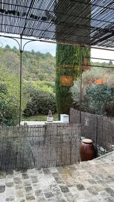 a view of a garden with a large vase on a patio at Le cabanon in Saint-Martin-de-Castillon