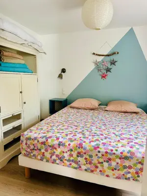 a bedroom with a bed with a colorful bedspread at Havre de paix proche centre ville, jardin, piscine in LʼIsle-sur-la-Sorgue