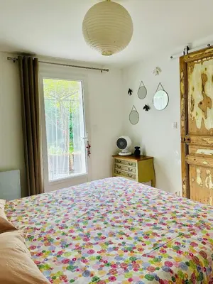a bedroom with a large bed and a window at Havre de paix proche centre ville, jardin, piscine in LʼIsle-sur-la-Sorgue