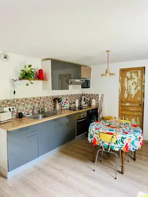 a kitchen with a table and a kitchen with a table and a tableablish at Havre de paix proche centre ville, jardin, piscine in LʼIsle-sur-la-Sorgue