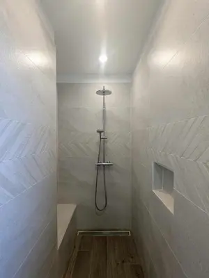 a bathroom with a shower in a room with a wall at Villa Papillon in Monteux