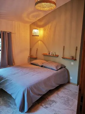 a bedroom with a large bed and a chandelier at Petit mas en Provence in Cornillon-Confoux