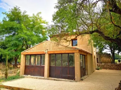 a small house with two garage doors on it at Petit mas en Provence in Cornillon-Confoux