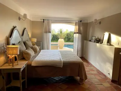 a bedroom with a large bed and a large window at La Maison du village in Pierrevert
