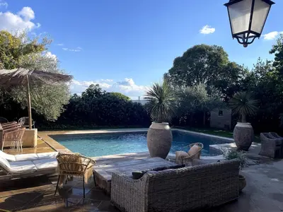 a patio with a pool with chairs and a table at La Maison du village in Pierrevert