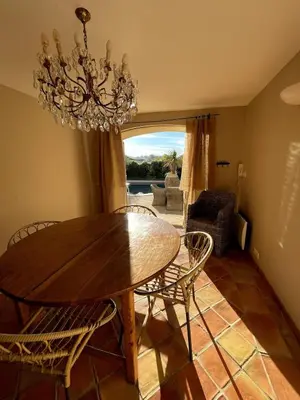 a dining room with a table and chairs and a chandelier at La Maison du village in Pierrevert