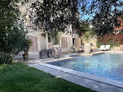 a swimming pool in the yard of a house at La Maison du village in Pierrevert