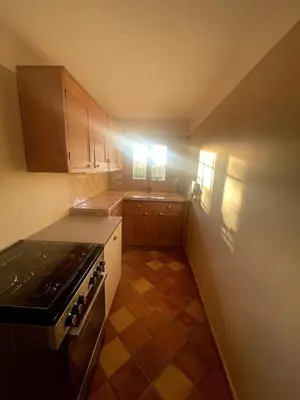a small kitchen with a stove and a sink at La Maison du village in Pierrevert