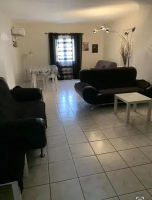 a living room with two couches and a table at Bel appartement de vacances 6 personnes in Caumont-sur-Durance