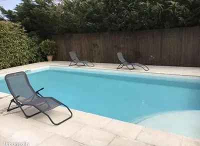 two chairs sitting next to a swimming pool at Bel appartement de vacances 6 personnes in Caumont-sur-Durance