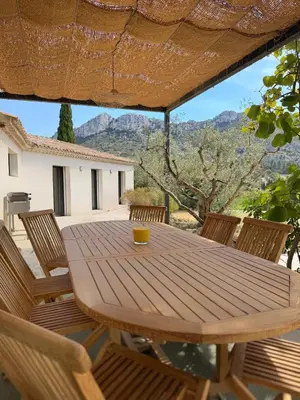 a wooden table and chairs on a patio at La Villa des Glauges in Eyguières