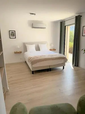 a bedroom with a bed and a large window at La Villa des Glauges in Eyguières