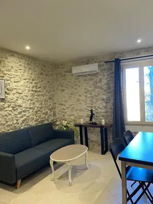 a living room with a blue couch and a table at Apartment in L'Isle-sur-la-Sorgue with parking in LʼIsle-sur-la-Sorgue