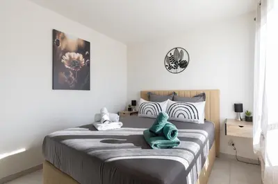 a bedroom with a large bed with white walls at Bella Vita Outdoor Jacuzzi in LʼIsle-sur-la-Sorgue
