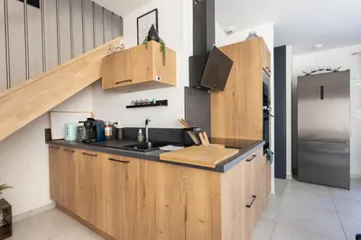 a kitchen with wooden cabinets and a refrigerator at Bella Vita Outdoor Jacuzzi in LʼIsle-sur-la-Sorgue