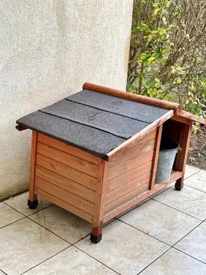a wooden dog house with a black top at La Bastide du Golfeur, Jardin et Piscine in Mallemort