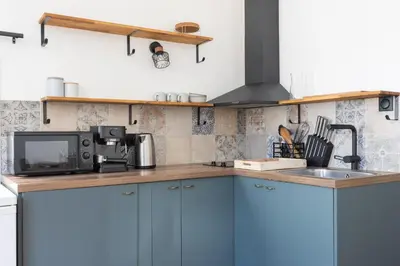 a kitchen with blue cabinets and a sink at Modern studio Le Renoir - Center of city - WiFi in Aix-en-Provence