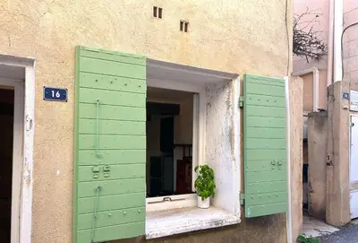 a window with a potted plant sitting in the middle of a building at Charmante maison de village avec clim et parking à proximité d'Aix-en-Provence in Éguilles