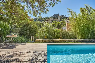 a swimming pool in a yard with a house at La Paulanne in Bonnieux