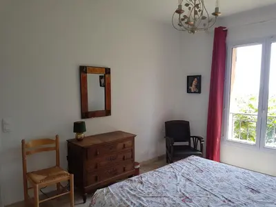 a bedroom with a bed and a dresser and a window at Holiday House Teulon in Éguilles