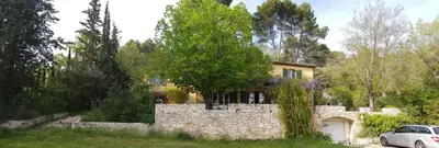 a car parked in front of a stone house at Holiday House Teulon in Éguilles