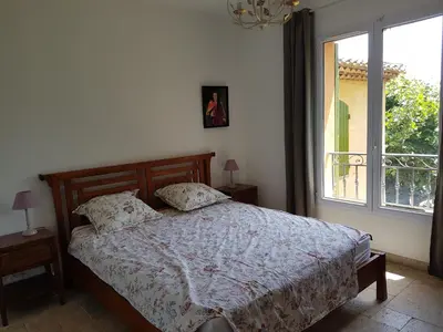 a bedroom with a bed and a large window at Holiday House Teulon in Éguilles