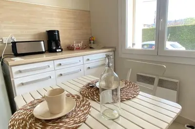 a kitchen with a table with two plates and a glass bottle at Family villa with garden and pool in LʼIsle-sur-la-Sorgue