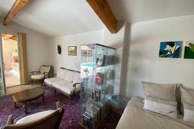 a living room with a couch and a glass cabinet at Family villa with garden and pool in LʼIsle-sur-la-Sorgue