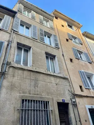 a tall building with windows on the side of it at L'essentiel - Studio cosy au cœur du centre ville historique d'Aix-en-Provence in Aix-en-Provence