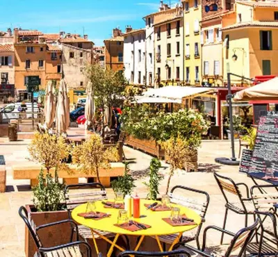 a yellow table and chairs on a city street at L'essentiel - Studio cosy au cœur du centre ville historique d'Aix-en-Provence in Aix-en-Provence