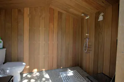 a wooden bathroom with a toilet and a shower at Bergerie provencale, 4 personnes, piscine in Gordes
