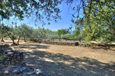 a park with a fence and trees and a field at Bergerie provencale, 4 personnes, piscine in Gordes