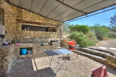 a stone building with a table and a stone oven at Bergerie provencale, 4 personnes, piscine in Gordes