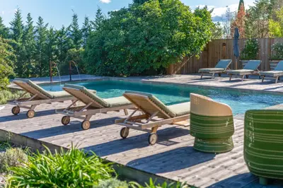 a pool with chaise lounge chairs and a swimming pool at Bastide de Guby in Saint-Saturnin-les-Apt