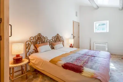 a bedroom with a large bed and two lamps at Bastide de Guby in Saint-Saturnin-les-Apt