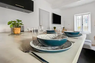 a kitchen with a sink and a black counter top at Maison rénovée avec terrasse et parking privé in Mallemort