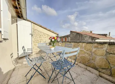 a table and chairs on the balcony of a house at Maison rénovée avec terrasse et parking privé in Mallemort