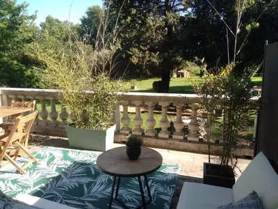 a patio with a table and a fence at Les feuillets de la Buire in Monteux