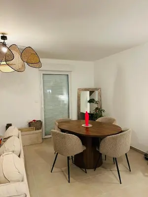 a living room with a wooden table and chairs at Jolie maison tout confort in Monteux