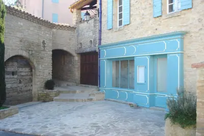 a building with a blue door and some stairs at Ventoux gîtes - appartements typiques avec vue sur le Mont Ventoux in Caromb