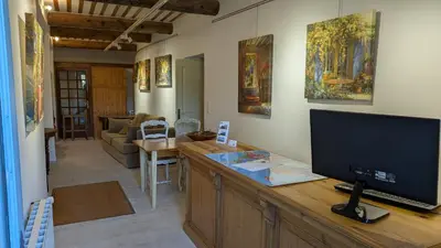 a living room with a flat screen tv on a wooden counter at Ventoux gîtes - appartements typiques avec vue sur le Mont Ventoux in Caromb