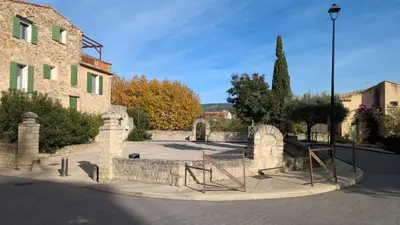 a stone fence in front of a building at Ventoux gîtes - appartements typiques avec vue sur le Mont Ventoux in Caromb