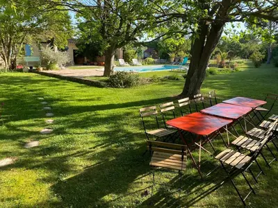 a picnic table and chairs under a tree in a yard at Mas Provençal - 300 m2 - 7 chambres in Cavaillon