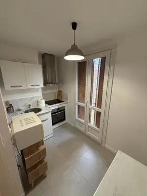 a kitchen with white cabinets and a sink and a window at Appartement moderne 3 chambres avec parking sécurisée in Aix-en-Provence
