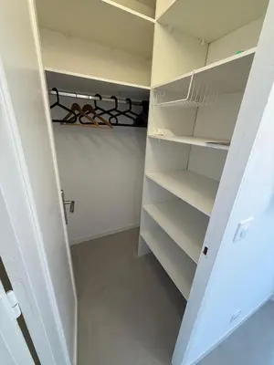 a white walk in closet with white shelves at Appartement moderne 3 chambres avec parking sécurisée in Aix-en-Provence