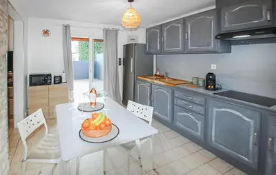 a kitchen with a table with a bowl of fruit on it at Amazing Home In Lauris in Lauris